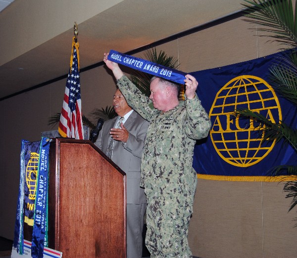 Lou Ramos, regional vice president, and Capt. Gerry Slevin, USN, chapter president, present the chapter’s Model Chapter Award for 2013 at the May meeting.